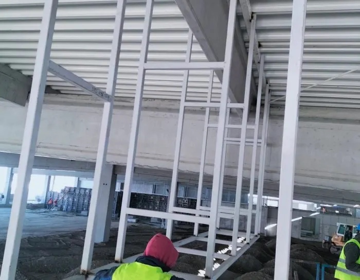 Kaufland — cadre metalice albe montate în șantier, sub un planșeu din beton